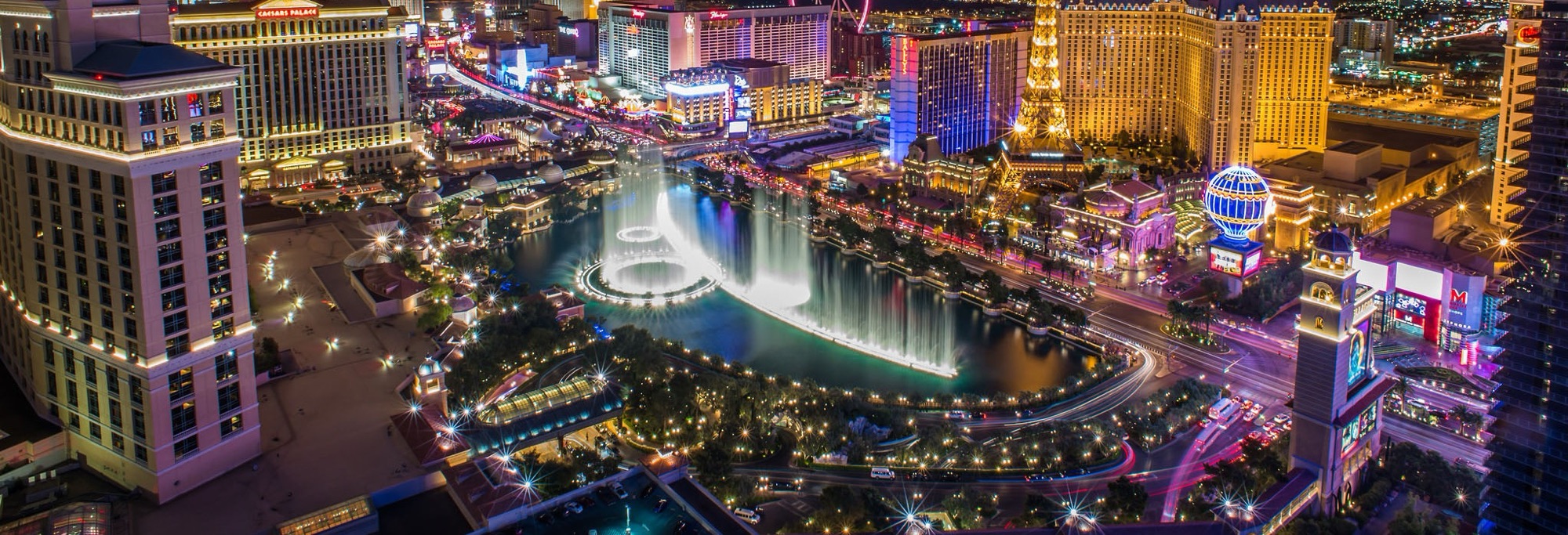 The Las Vegas Strip at night from above, with the Bellagio fountains lit up