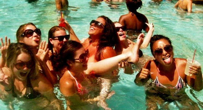 A group of friends in sunglasses partying in a Las Vegas hotel pool